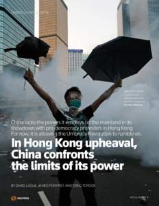 UMBRELLA REVOLUTION  DEMOCRACY QUEST: A protester holds umbrellas aloft as tear gas swirls in Hong Kong.